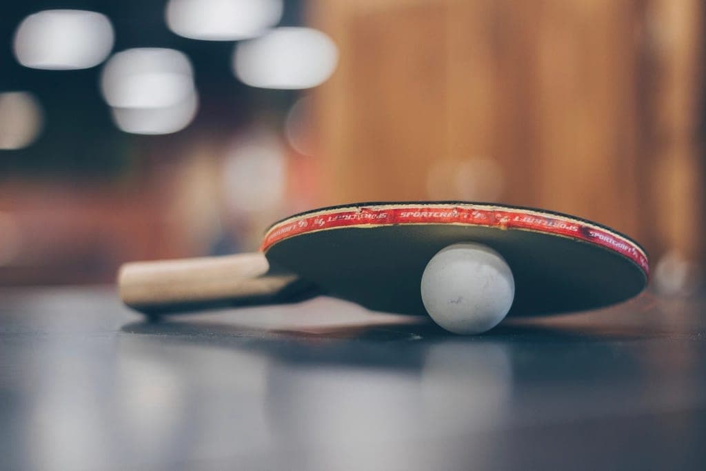 Tischtennis: Schläger mit Ball auf der Platte